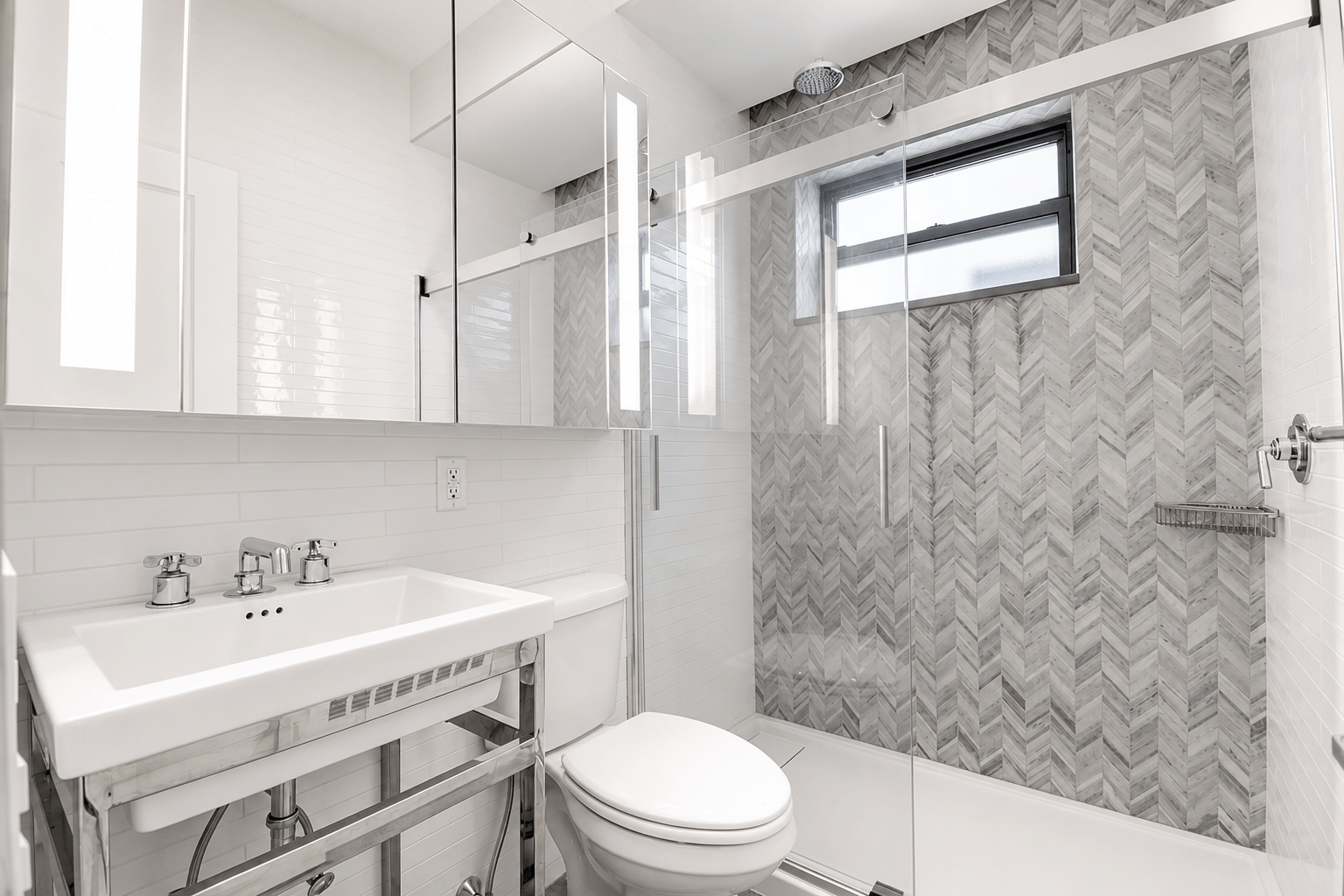 A bathroom with a toilet, sink, and shower.